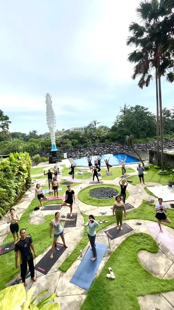Students practicing outdoor yoga near the pool at Bali 300 hour YTT campus