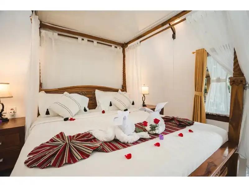 Canopy bed with welcome decoration in a private room at DivinePath Ubud campus