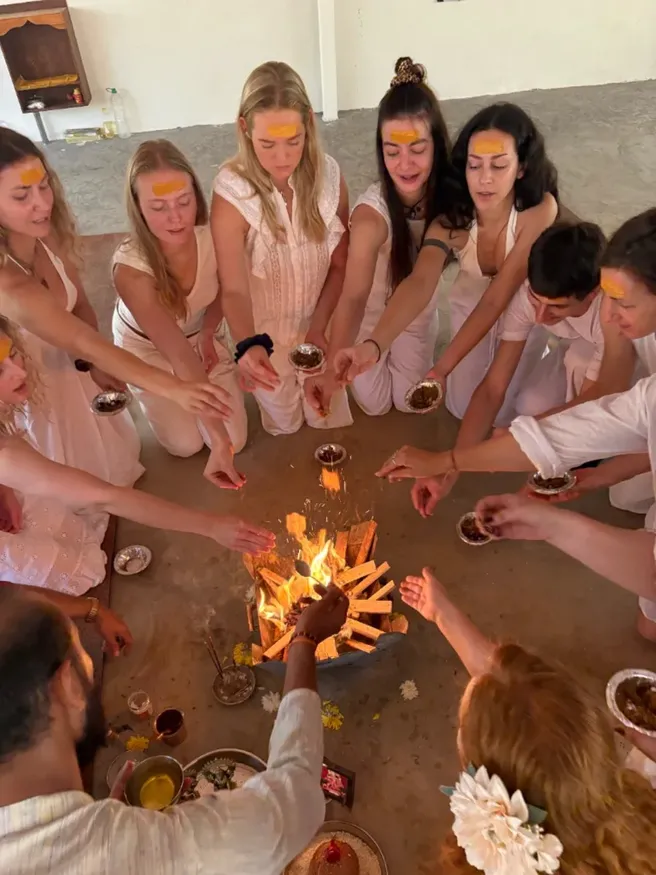 Students offering herbs into the fire ritual during 300 hour yoga TTC in Goa