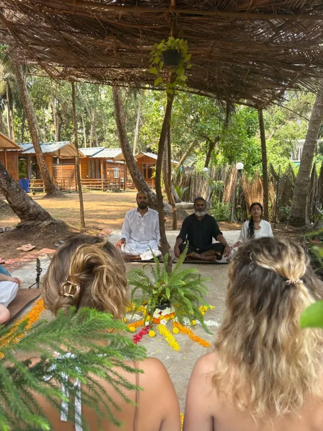 Outdoor meditation session under coconut trees at DivinePath 300 hour YTT Goa campus