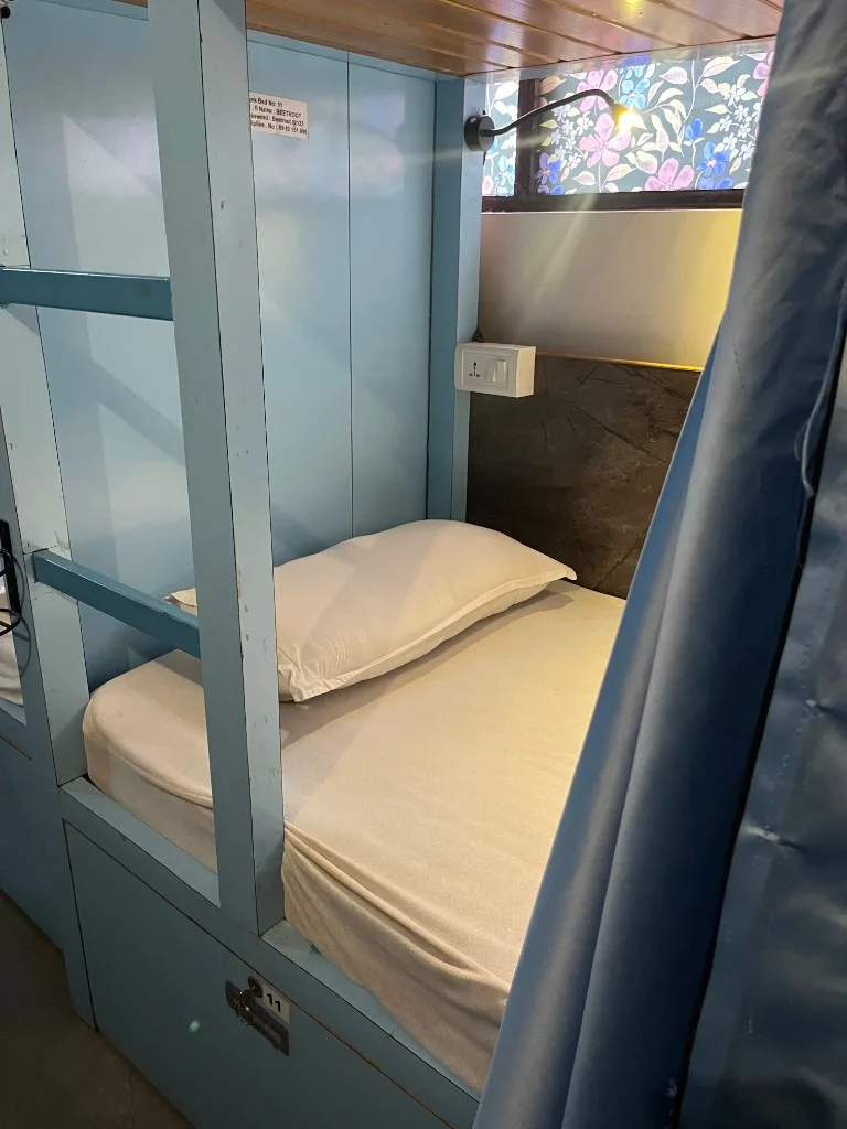 Modern dorm bunk pod interior with linen, bedside lamp, and campus Wi‑Fi at DivinePath Goa retreat