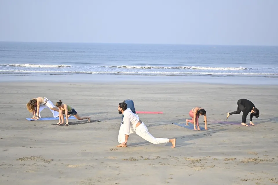 Group beach yoga practice near Arambol
