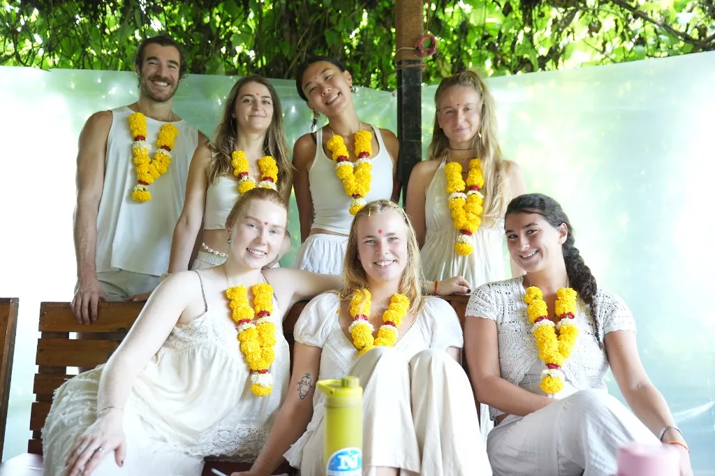 200 hour yoga teacher training group after opening ceremony in white and marigold garlands