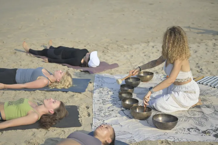 Group sound bath on Arambol Beach during DivinePath sound healing training