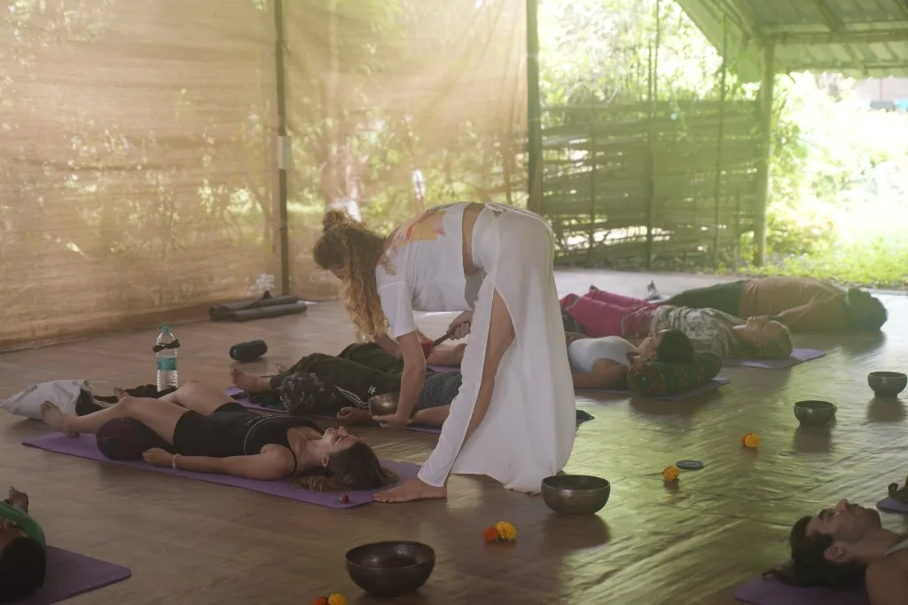 Instructor leading a singing bowl sound bath in the DivinePath Goa yoga shala