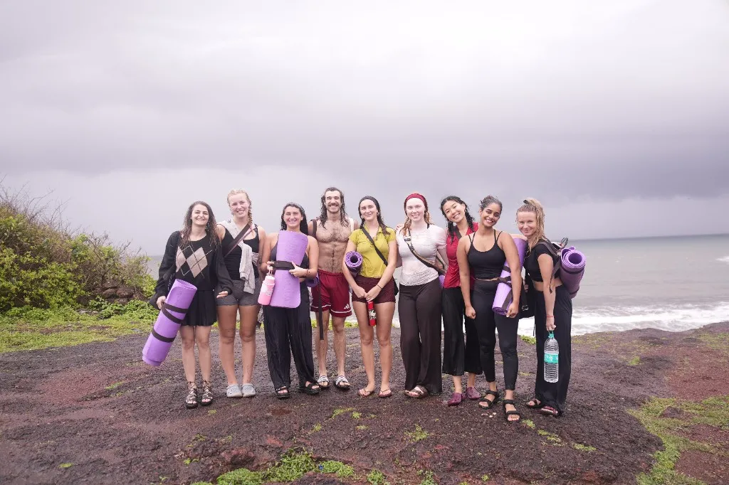 Divinepath students with yoga mats on the cliffs above Arambol Beach, Goa