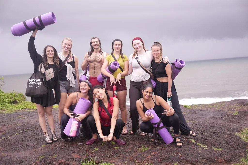 Divinepath students with yoga mats on a coastal outing during training