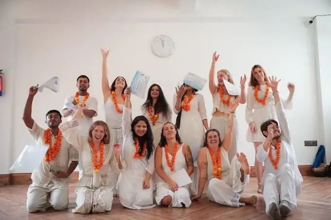 Graduates after 500-hour yoga teacher training Rishikesh in the Tapovan hall with marigold garlands and school certificates