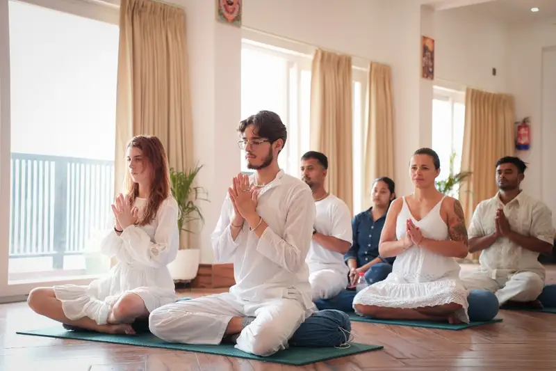 Students seated in prayer during a class on the 500-hour course at the Tapovan yoga hall