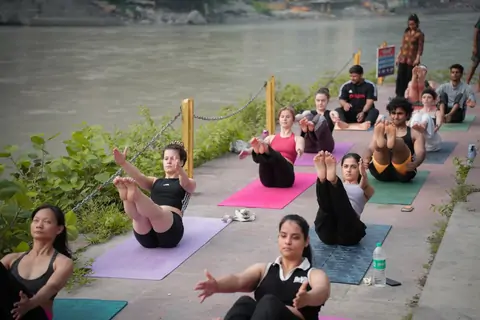 Navasana practice on the Ganga ghat during 300 hour yoga teacher training in Rishikesh