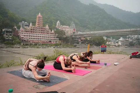 Paschimottanasana seated forward fold on the Ganga ghat in Rishikesh
