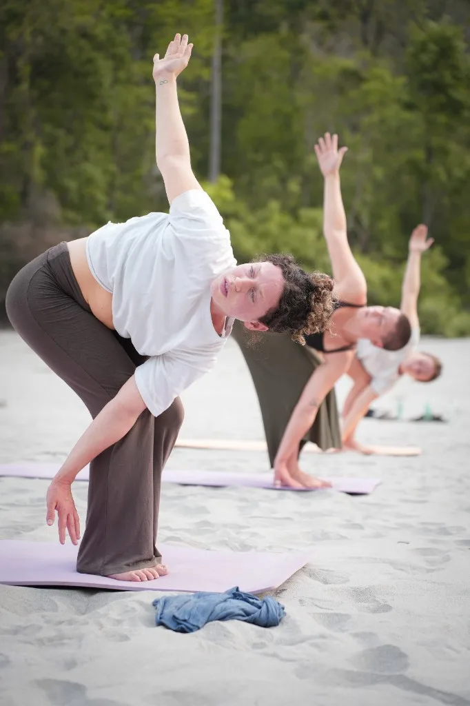 Cow pose outdoor yoga on sand Rishikesh