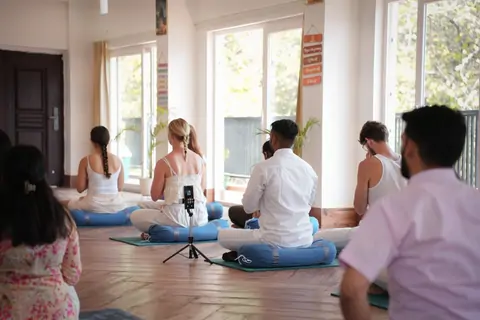Asana class facing the front of the Tapovan hall
