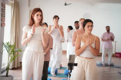 Trainees in namaste in the Tapovan yoga hall
