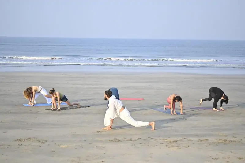 DivinePath students practising asana on the beach near the Goa campus during yoga teacher training