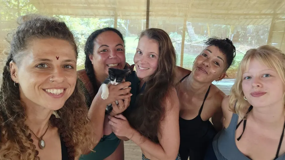 Beginner yoga teacher training students smiling together inside the Divinepath Goa shala